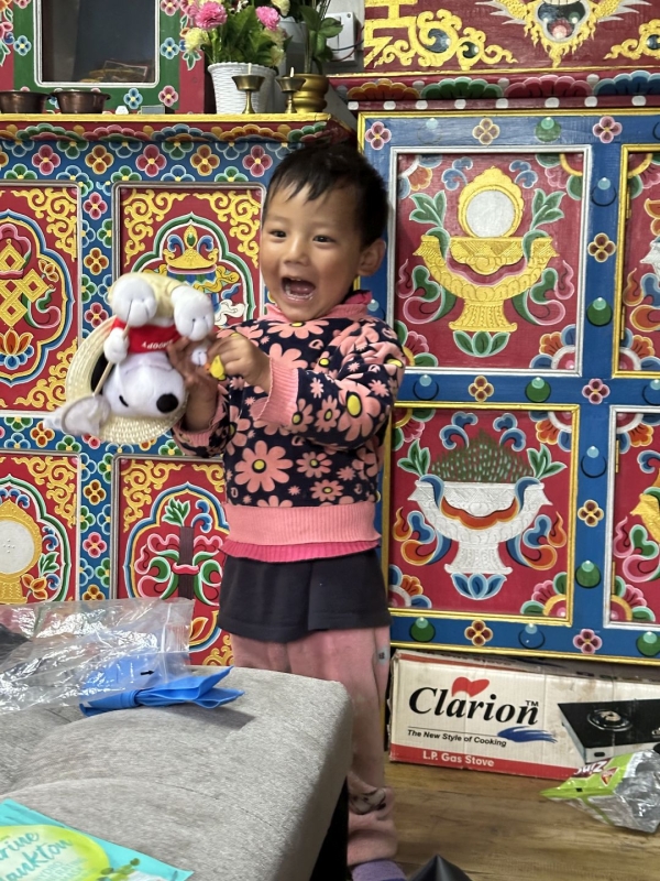 ぬいぐるみを持って、仏壇の前で満面の笑顔