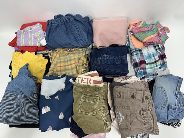 子供服をサイズ別に仕分けて、寄付用に梱包します。