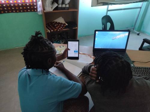 タブレットとノートパソコンを使って、学習するアフリカの国ザンビアのセカンダリスクールの子供達